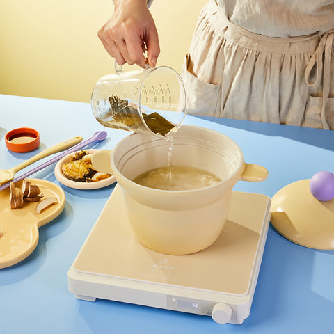 Yellow ceramic rice pot on an induction cooktop, perfect for cooking rice or broth, shown with fresh ingredients and a modern design."

Keywords: induction-compatible pot, ceramic rice cooker, yellow cookware, versatile cooking pot, aesthetic kitchenware

