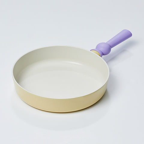 A pastel-colored frypan with a yellow body and a purple handle, displayed on a white background