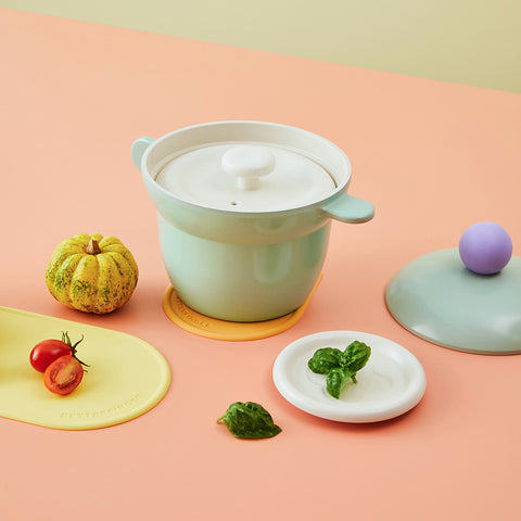 Mint rice pot with a ceramic steam lid, fresh basil leaves, cherry tomatoes, and a decorative pumpkin in a pastel-colored setting."

Keywords: steam pot, rice cooker, cooking pot, ceramic kitchenware, pastel kitchen decor