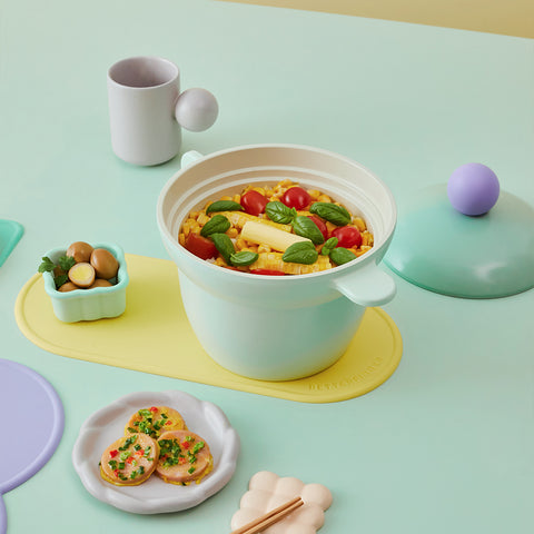 Pastel mint ceramic pot filled with fresh vegetables, paired with aesthetic dishware and decorative table settings."

Keywords: kitchen decor, ceramic rice cooker, aesthetic dining, cooking pot, pastel kitchen items