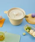 Minimalist white ceramic steam lid with ergonomic design, paired with a pastel yellow rice pot for versatile cooking."

Keywords: steam lid, ceramic lid, ergonomic kitchen tool, yellow cookware accessory, modern kitchenware