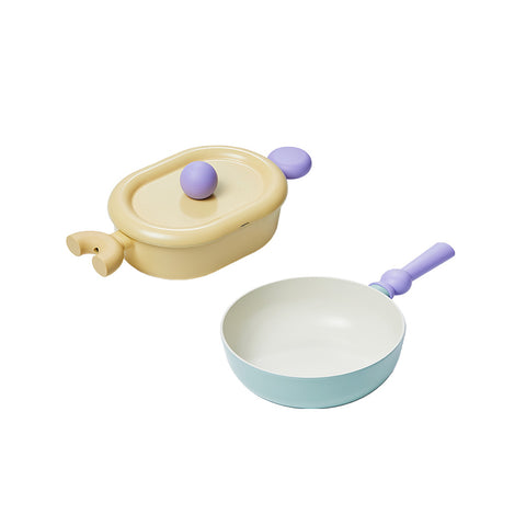 A set of two pastel-colored cookware items, including a yellow oval pot with a lid and a light green frying pan, both with purple handles, displayed on a white background