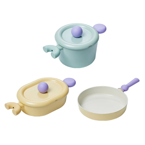 A set of three pastel-colored cookware items, including a light green pot with a lid, a yellow oval pot with a lid, and a yellow frying pan, all with purple handles, displayed on a white background